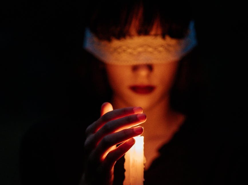 blindfolded woman with a lit candle